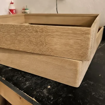 Dřevěná svítidla BLOKK 60x60 v dílně na stole